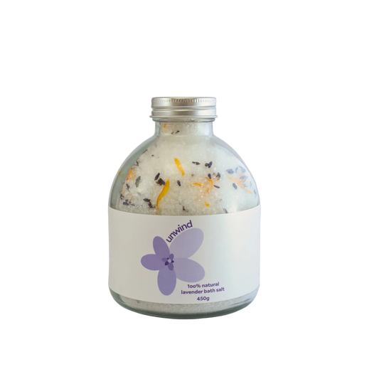 Bottle of Unwind lavender bath salts on a white background
